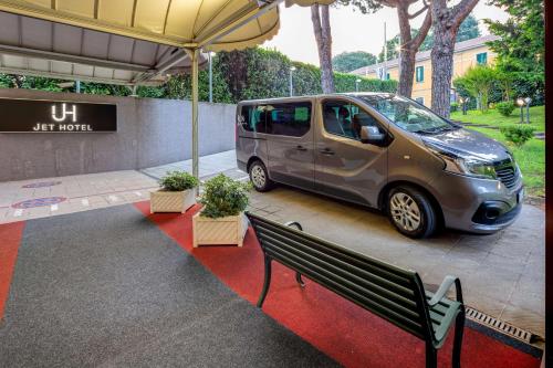 a van parked under an umbrella next to a bench at Jet Hotel, Sure Hotel Collection by Best Western in Gallarate