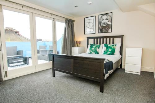 um quarto com uma cama e uma grande janela em Brighton Lanes Townhouse em Brighton & Hove