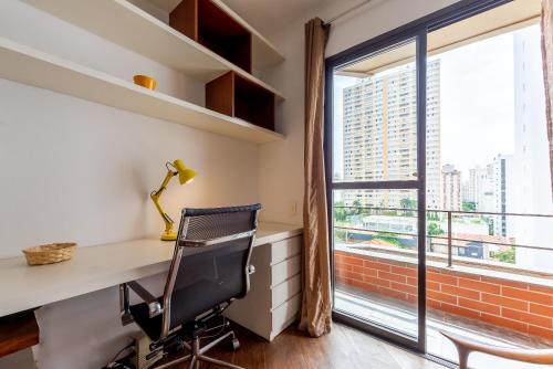 oficina con escritorio, silla y ventana en Conforto e Charme em Pinheiros, en São Paulo