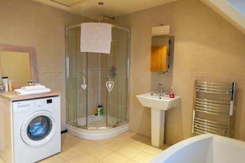 a bathroom with a washing machine and a sink at Apartment No.2 - The Old Red King Pub MCR in Manchester