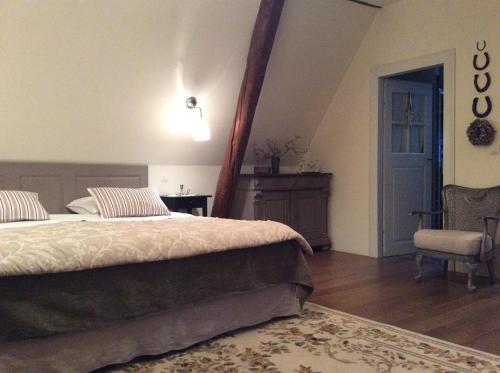 a bedroom with a bed and a table and a chair at Aux temps d'avant in Gundershoffen