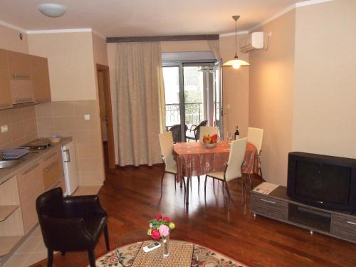 Una sala de estar con una mesa de comedor y una cocina. en Beachfront Apartments Oaza 2, en Petrovac na Moru
