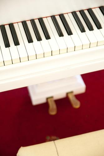 a white piano with black keys at Hotel Dwór Polski in Wrocław