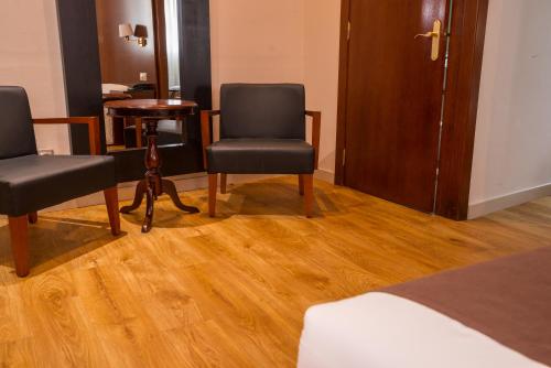 a hotel room with two chairs and a table at Ramon Berenguer IV in Lleida