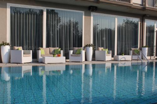 a hotel with a pool with chairs and a building at Hotel Liberty Beach - Parking & Beach in Riccione