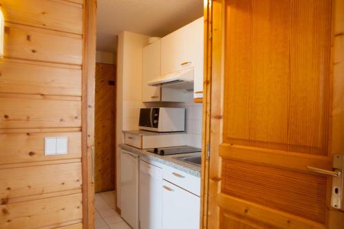 a small kitchen with a stove and a microwave at Le Floralp in Combloux