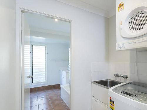 a white kitchen with a sink and a microwave at Absolute in Point Lookout