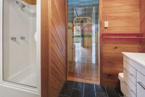 a bathroom with a shower and a glass door at 112 Mooloomba Road in Point Lookout