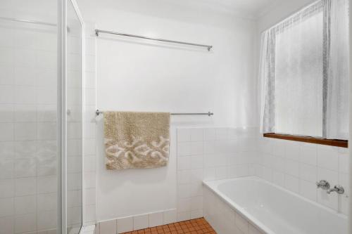 a white bathroom with a tub and a shower at Eyrie in Point Lookout