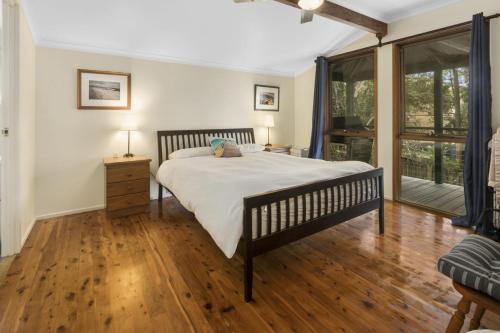 a bedroom with a bed and a wooden floor at Eyrie in Point Lookout