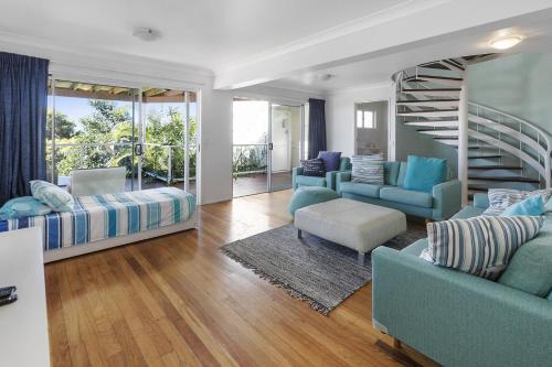 una sala de estar con muebles azules y una escalera de caracol en The Mariner, en Point Lookout