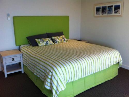 a bedroom with a bed with a green headboard at Azul del Mar in Point Lookout