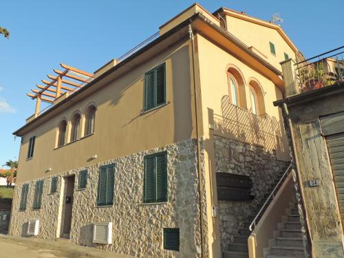 an old stone building with green shutters on it at Sogno Azzurro - ArgonautiVacanze in Porto Azzurro