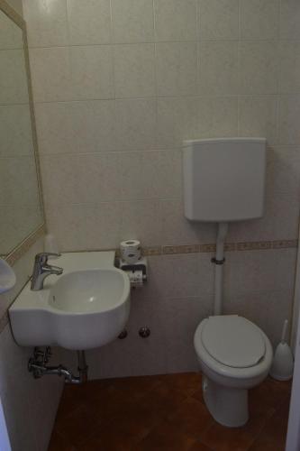 a bathroom with a white toilet and a sink at Hotel Apis in Rimini