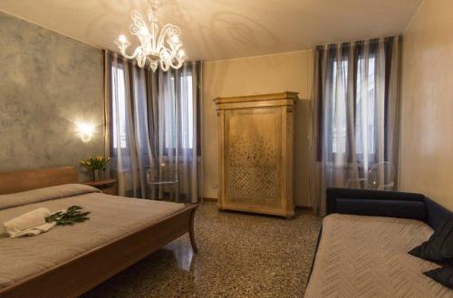 a bedroom with a bed and a chandelier at Taverna San Lio in Venice