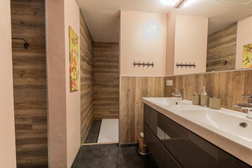 ノイシュティフト・イム・シュトゥーバイタールにあるApartments Grillstubeの白い洗面台と木製の壁が備わるバスルーム