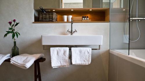 a bathroom with a sink and a shower and towels at Speicher7 Hotel in Mannheim