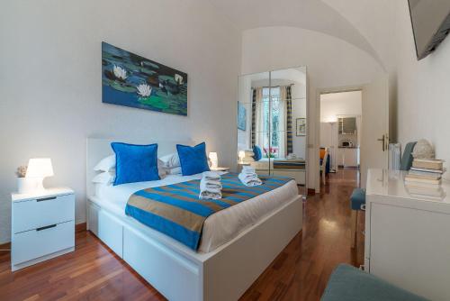 a bedroom with a large bed with blue pillows at CS Piazza Venezia Apartment in Rome