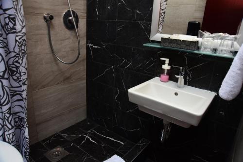 a bathroom with a sink and a shower at Hotel Meridijan16 in Zagreb