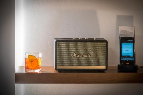 a radio on a shelf with a drink and a cell phone at Happy Cretan Suites in Agia Pelagia