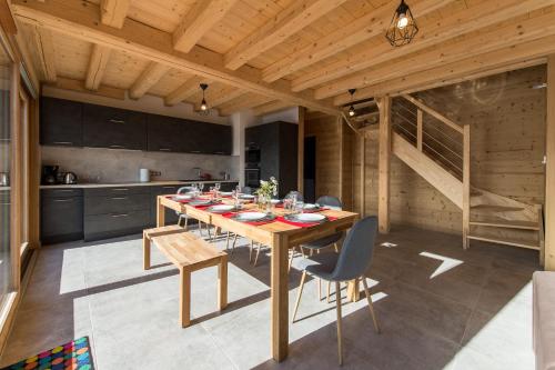 ein Esszimmer mit einem Tisch und Stühlen in einer Küche in der Unterkunft ODYSSEE B301 Duplex mansarde sur les pistes, vue panoramique in La Toussuire