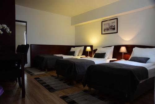 ein Hotelzimmer mit 3 Betten und 2 Lampen in der Unterkunft Hotel Meridijan16 in Zagreb