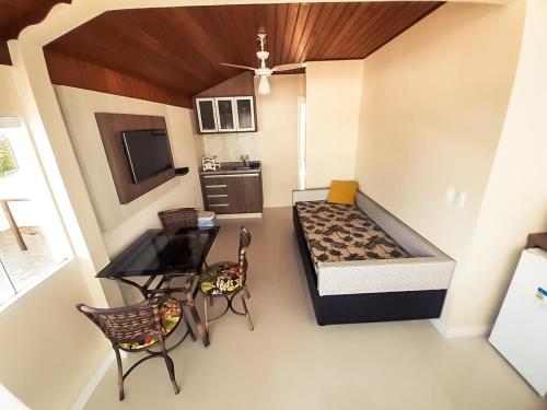 Habitación pequeña con cama, mesa y sillas en Pousada Recanto Estaleiro Residencial, en Balneário Camboriú