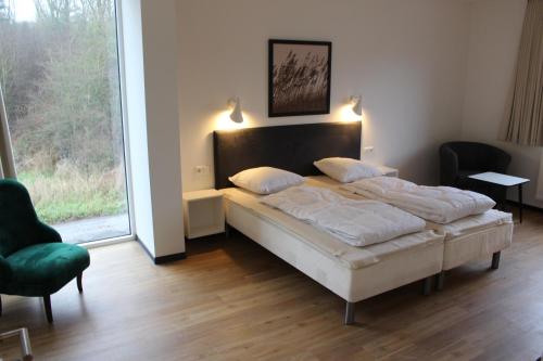 ein Schlafzimmer mit einem Bett und einem großen Fenster in der Unterkunft Dünenhaus Wohnung11 in Lübeck