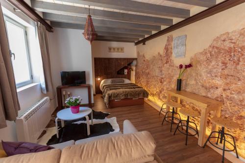 Habitación con cama, sofá y mesa. en Domus Lapidis - El Taller en Bogarra