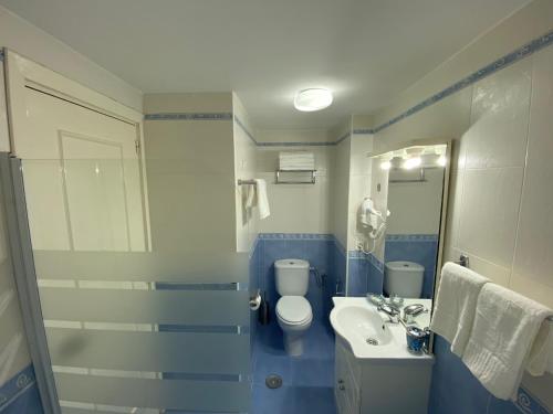 une salle de bain bleue et blanche avec des toilettes et un lavabo dans l'établissement MiNERVA, à Benalmádena