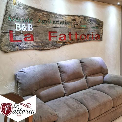 a couch in a room with a sign on the wall at Agriturismo La Fattoria B&B in Limatola