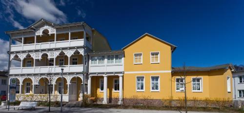 a yellow and white building with a blue sky at Haus Sonne in Ostseebad Sellin