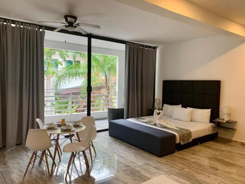 a bedroom with a bed and a table and chairs at SILVERSANDS Hotel Boutique - 5Th Ave in Playa del Carmen