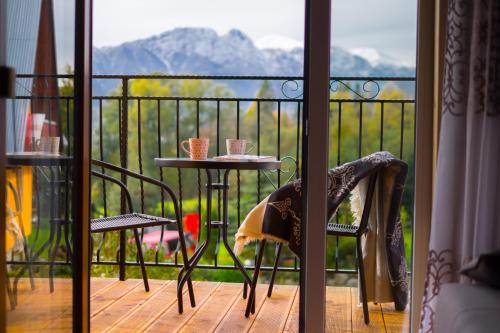 einen Tisch und Stühle auf einem Balkon mit Aussicht in der Unterkunft Apartamenty "Pod Tatrami" in Zakopane