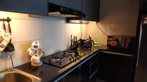 a kitchen with a stove top oven next to a sink at Conezion Luxury 3BR for 7pax @IOI Resort Putrajaya in Putrajaya
