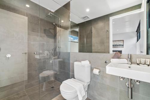 a bathroom with a toilet and a shower and a sink at Convenient Beachside Studio Apartment in Melbourne