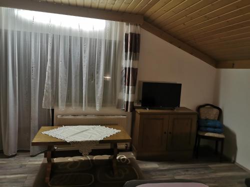 Ferienwohnung Seidl Top 2 في راوريس: غرفة معيشة مع طاولة وتلفزيون