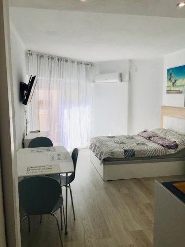 a bedroom with a bed and a desk and chairs at Estudio Habaneras,38 p 103 in Torrevieja