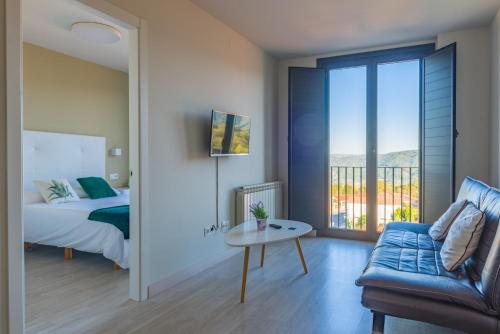 a bedroom with a bed and a couch and a balcony at O balcón da ribeira in Parada del Sil