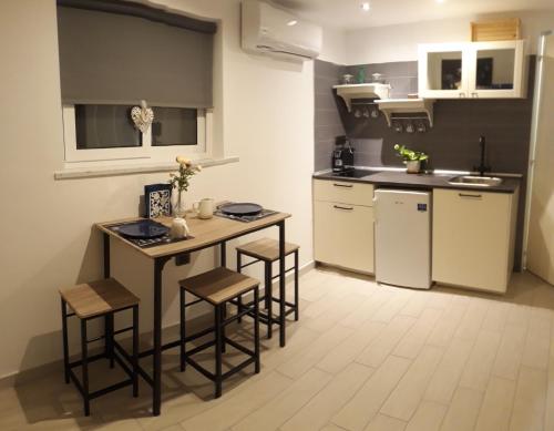 拿坡里的住宿－Nadine Penthouse Studio，小厨房配有桌子和凳子