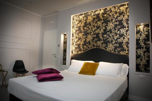 ein Schlafzimmer mit einem großen Bett mit lila und goldenen Kissen in der Unterkunft Principessa Isabella Luxury Rooms in Salerno