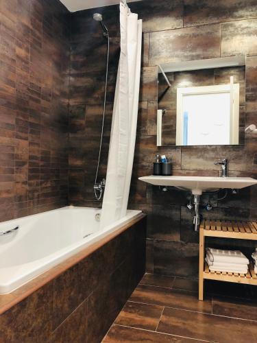 a bathroom with a tub and a sink at Apartament Cau del llop in Llança