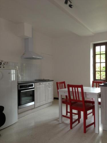 a kitchen with a table and two chairs and a stove at Appart dans fermette in Audeville