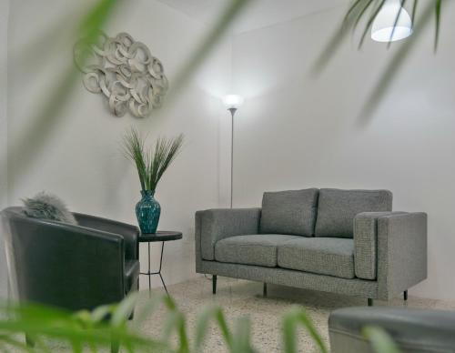 uma sala de estar com um sofá e uma televisão em In & Out Hotel em Guatemala