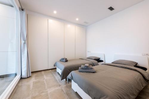 two beds in a room with white walls at Puerto Banus Frontline Apartment with Amazing Sea Views in Marbella