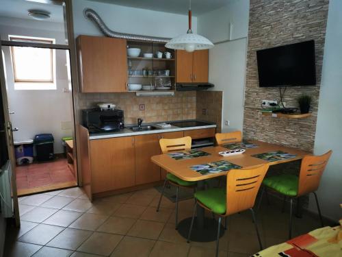 a kitchen with a table and chairs and a kitchen with a television at Apartma David Rogla in Zreče