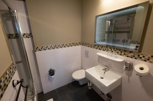a bathroom with a sink, toilet and bathtub at Hotel Hamburg Altona in Hamburg