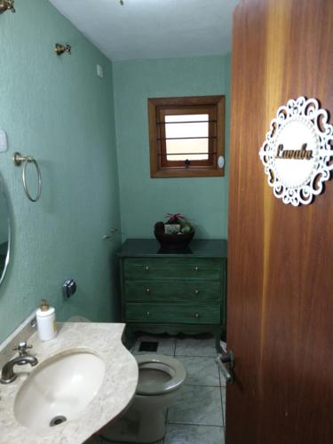 y baño con lavabo, aseo y espejo. en El Refugio 700, en Gramado