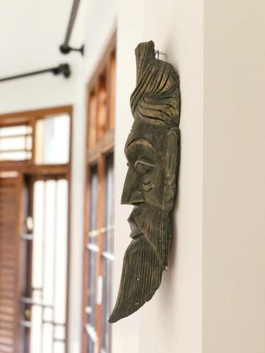 a statue of a head on the side of a building at Desire Village Rakwana in Rakwana