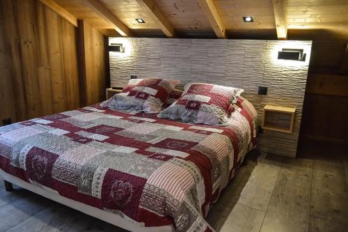 a large bed in a room with a brick wall at Chalet Les Camélias SPA in Gérardmer